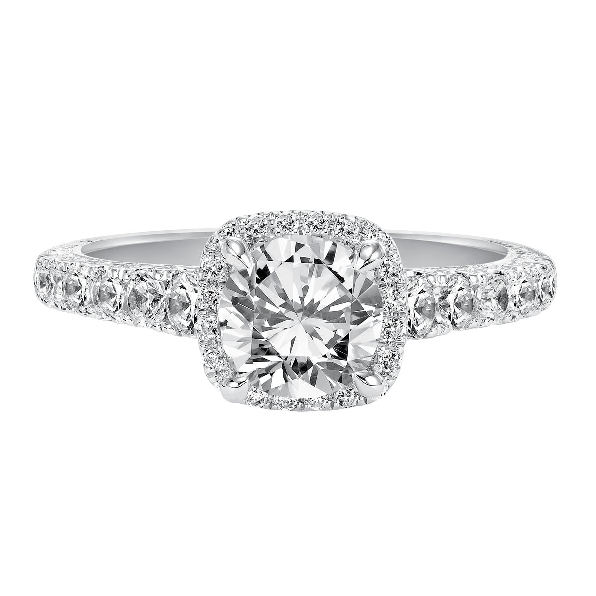 This alluring round diamond engagement ring gleams with a prong set diamond halo and prong set diamond band enhanced with delicate engraving