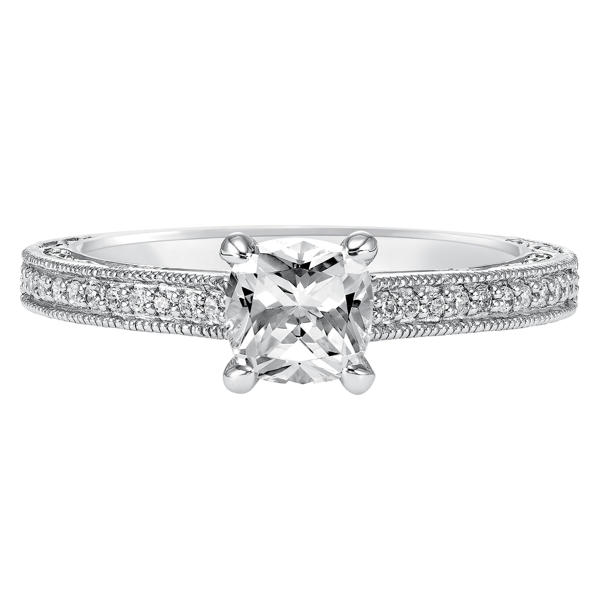 This charming cushion cut engagement ring features an exquisite prong set diamond band enhanced with milgrain and intricate filigree